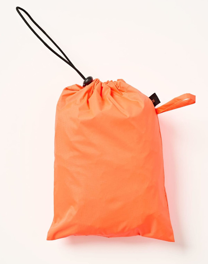An orange waterproof bag with a drawstring closure, suitable for storing lightweight nylon rain pants.
