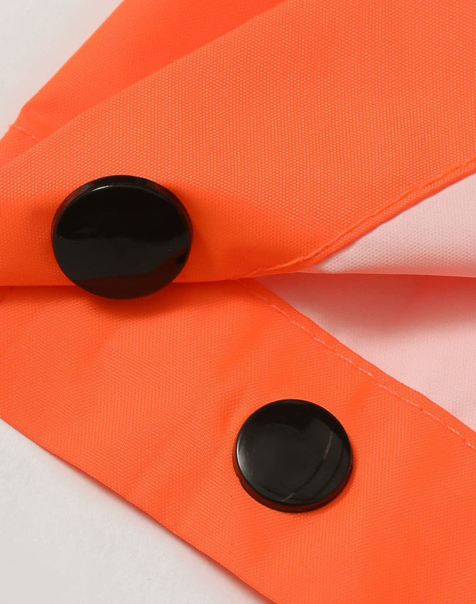 Lightweight nylon waterproof rain pants in bright orange with black buttons. Features a smooth fabric texture.