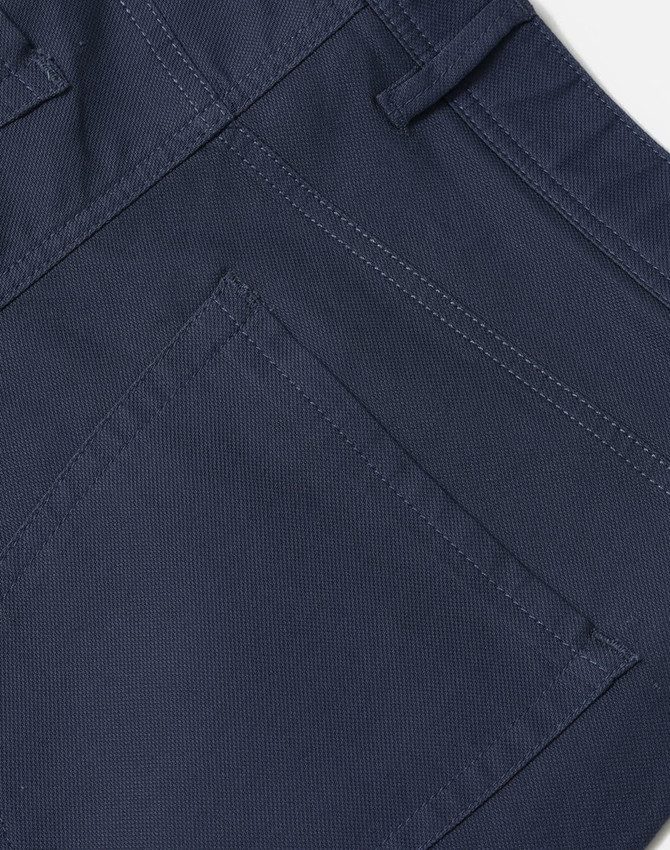 A close-up of navy flexi chino pants, highlighting the stitching and pocket details. The fabric appears sturdy and stylish.