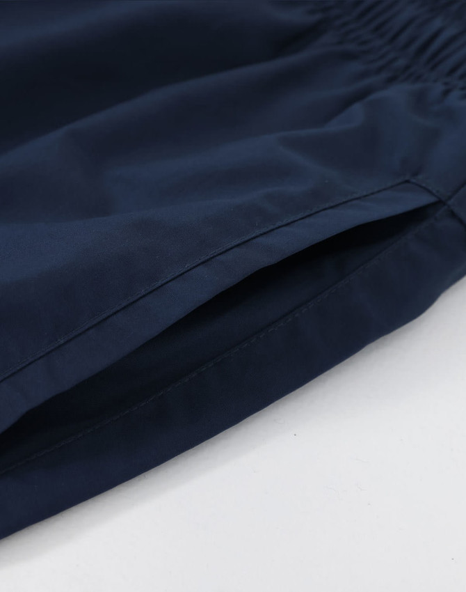 Navy unisex mercerised cotton shorts with an elastic waistband and side pockets. Features a branding logo.