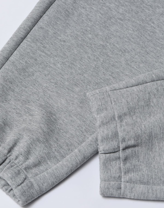 A pair of grey unisex sweatpants featuring an elasticated cuff and a logo on the waistband.