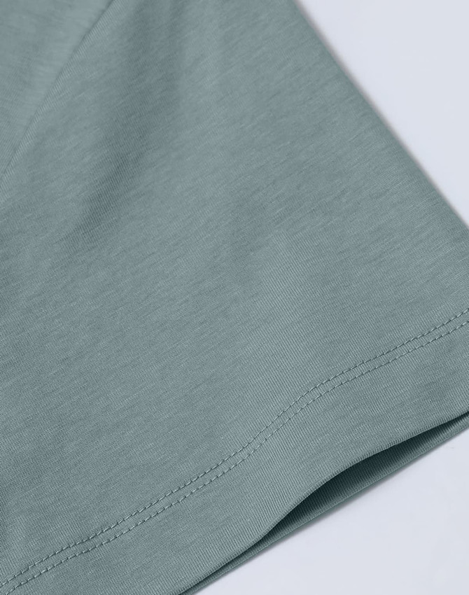 A close-up of a ladies' premium short-sleeve tee shirt in a soft green colour, featuring a smooth fabric texture.