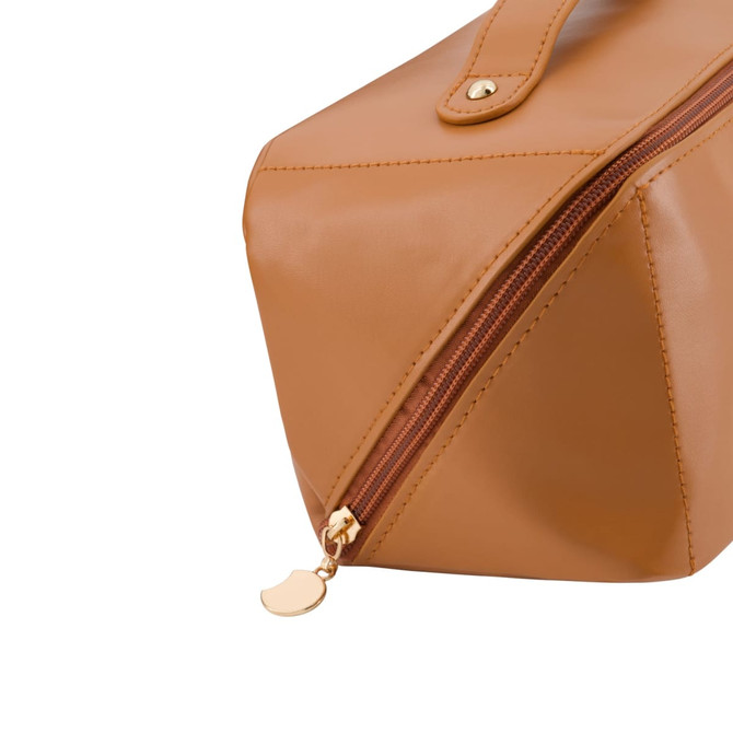 A tan toiletry bag with a gold zipper, featuring a sleek design and a branding logo.