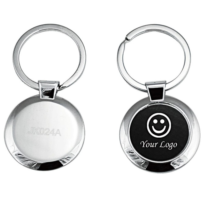 A keyring featuring a polished silver design with a circular shape and a logo area on one side.