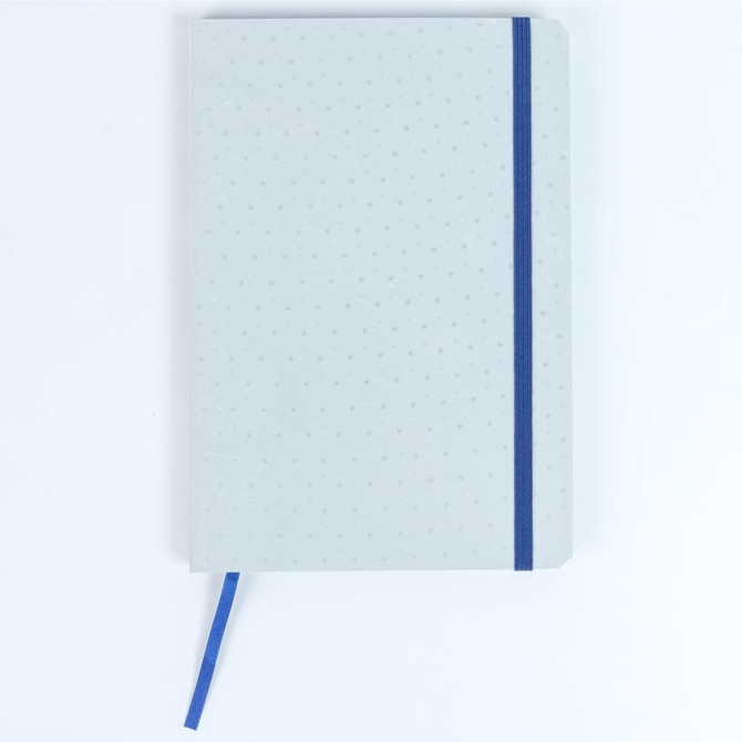 A grey notebook featuring a blue elastic band and dotted design, complete with a ribbon marker.