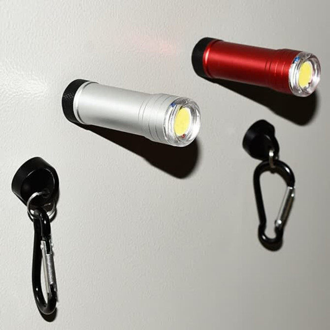 Two compact flashlights in silver and red, mounted on a wall, alongside black carabiners for easy attachment.