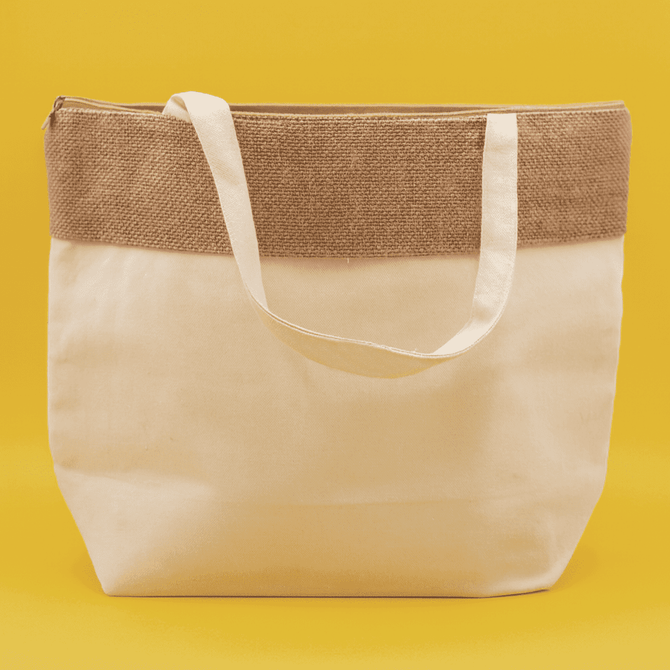 A jute and cotton cooler bag in cream with a brown jute top and white straps, featuring a logo.