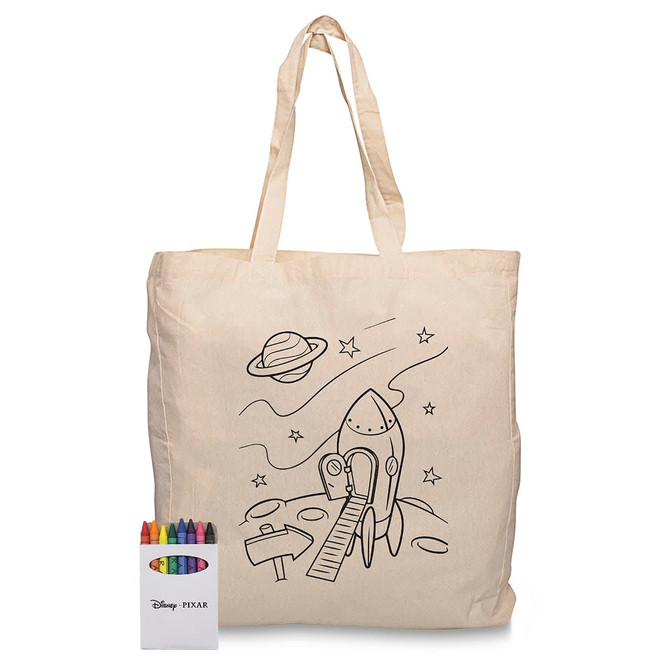 A beige cotton tote bag featuring a rocket and space design, accompanied by a set of crayons in various colours.