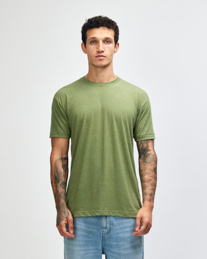 A man wearing an olive green American Apparel tri-blend T-shirt and blue jeans, standing against a plain background.