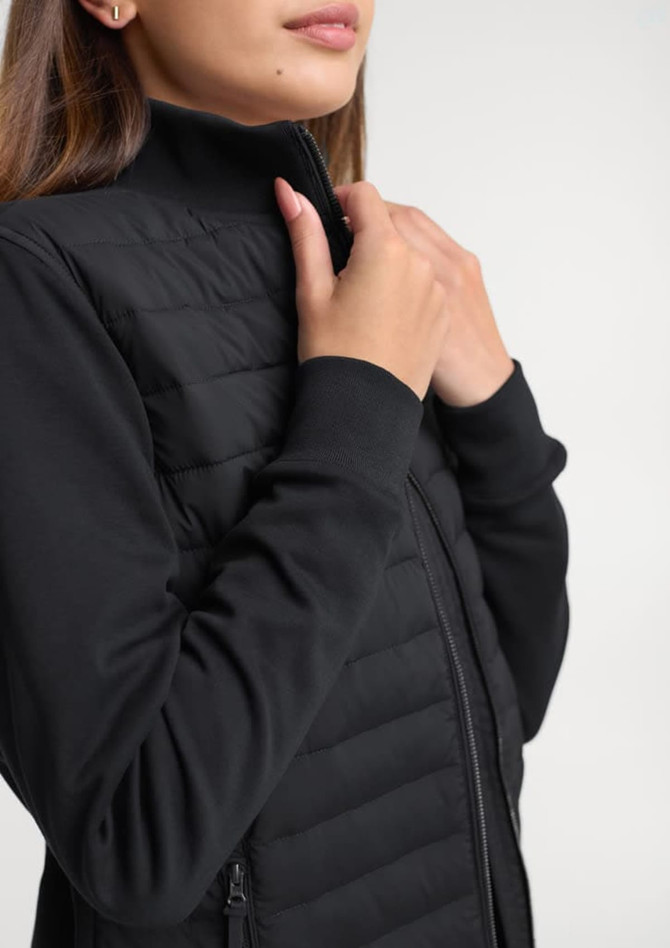 A women's tailored jacket in black, featuring a zip closure and quilted design on the body.