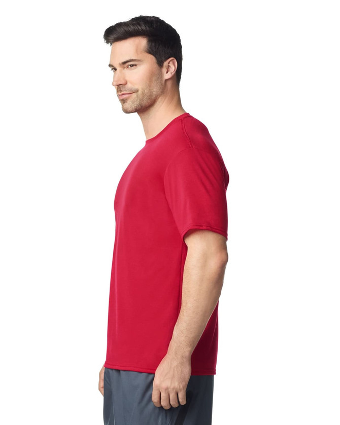 A red Gildan Performance adult T-shirt is shown on a model from the side, featuring a simple design and a logo.