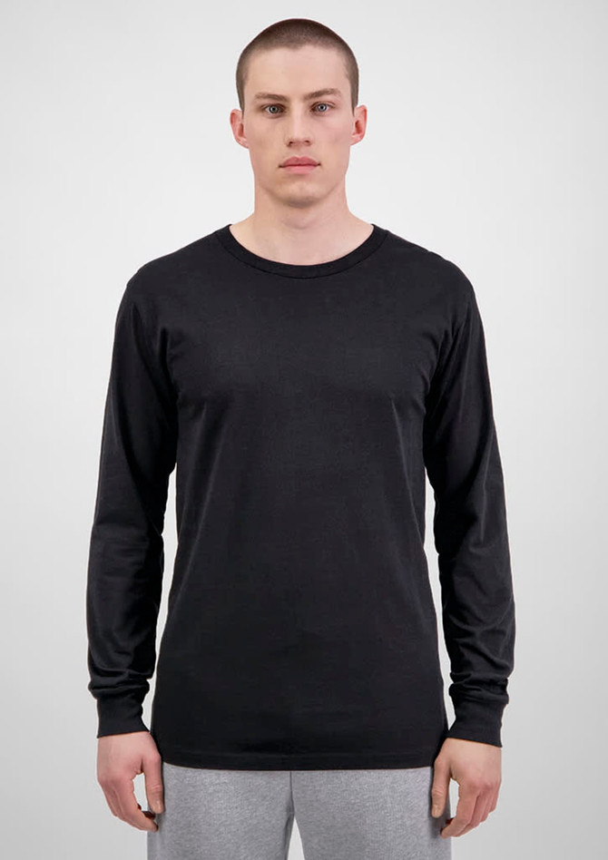 A black long sleeve t-shirt displayed on a model with grey sweatpants. The shirt features a logo.