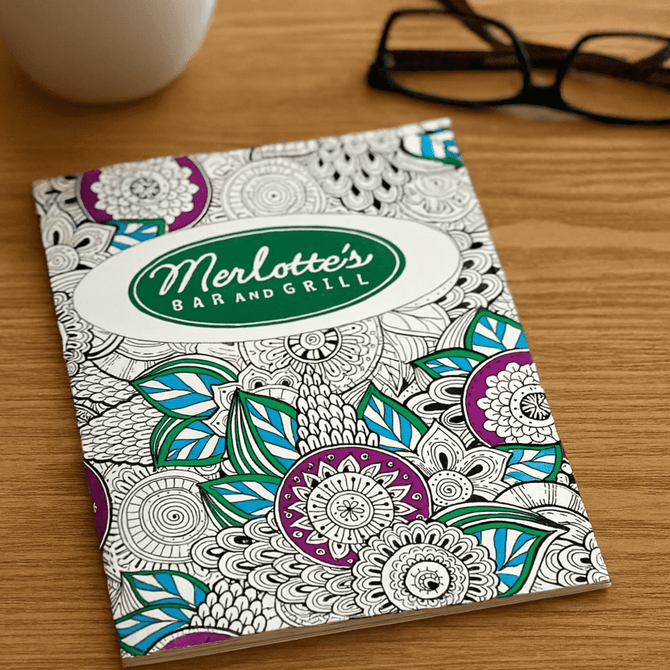 A5 colouring book featuring intricate floral designs in purple, blue, and green, with a logo on the cover.