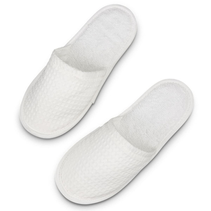 A pair of white waffle slippers with a textured surface and a soft, plush interior.