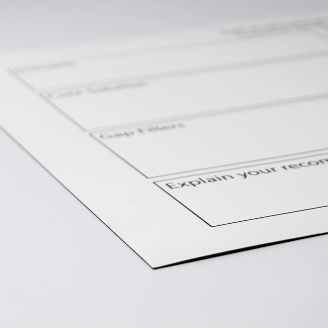 A white magnetic whiteboard with black outline sections for notes, featuring a logo in the corner.