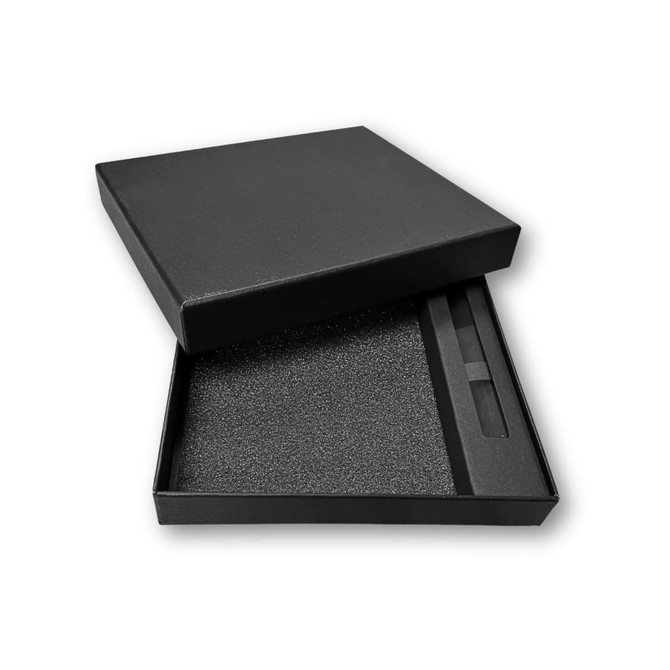 A black gift box containing a notebook and pen, lined with foam for protection.