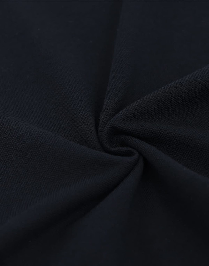 A close-up of navy blue cotton/poly pique fabric, featuring a soft, textured surface.