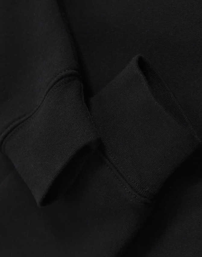 A black half-zip collar fleecy sweat featuring a close-up of the cuff detail. It includes a branding logo.