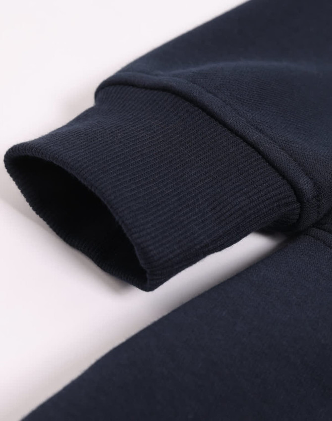 A close-up view of a navy fleece half zip work sweatshirt, showcasing the ribbed cuff detail and soft fabric.