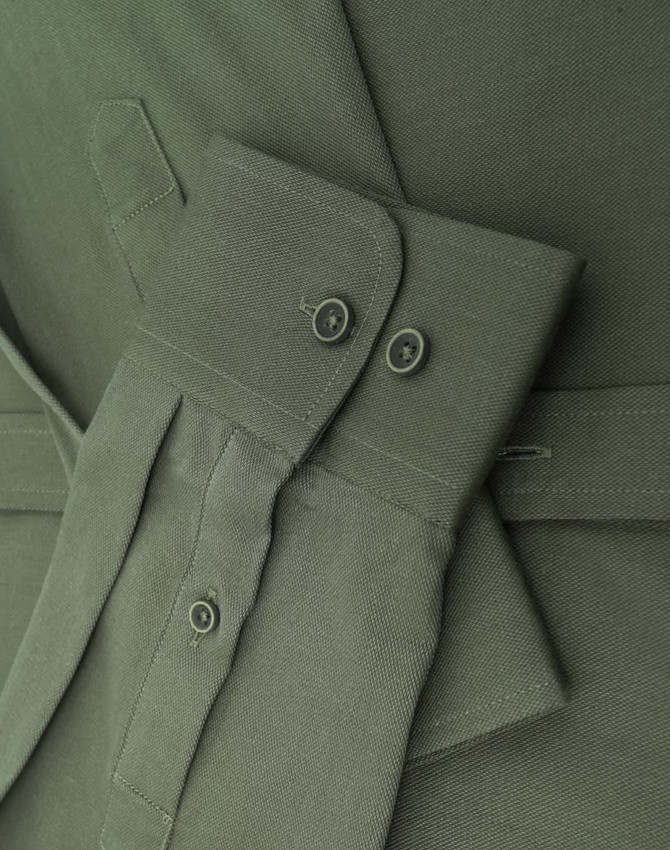 A close-up of a men's smart casual cotton blend long-sleeve shirt in olive green, featuring button details and cuffs.