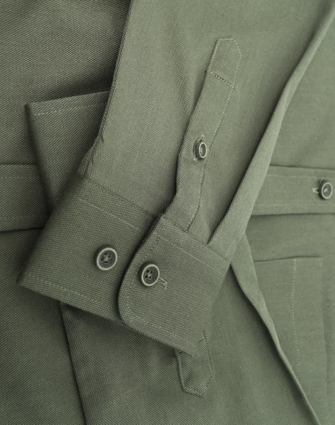 A green cotton blend long-sleeve shirt featuring buttoned cuffs and a logo.