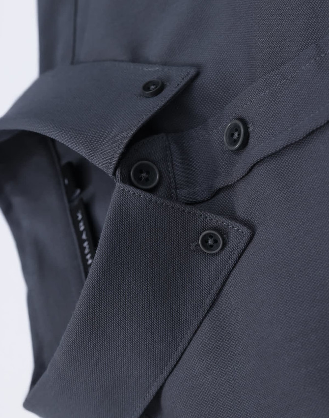 A close-up of a grey cotton blend long-sleeve shirt featuring button details and a collar.
