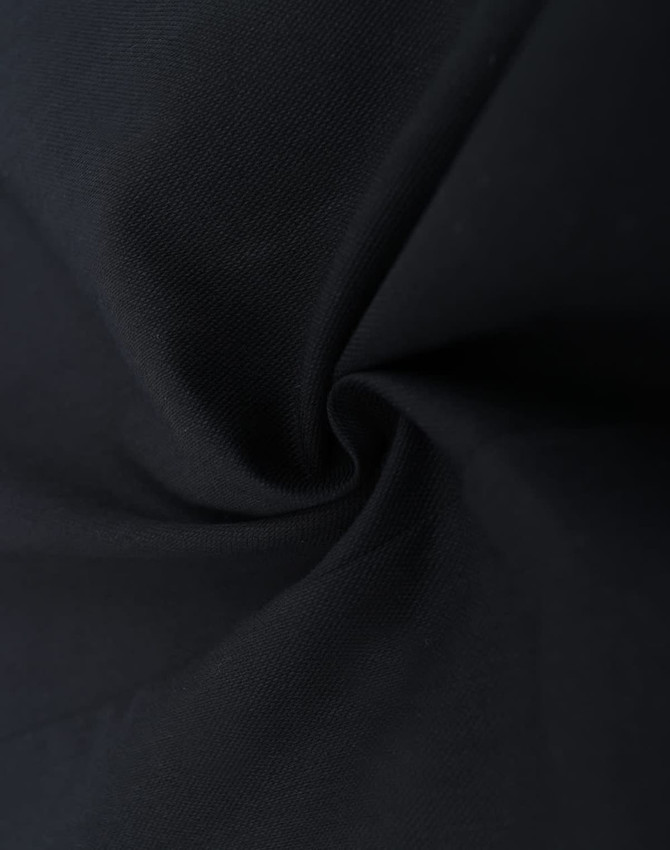 A close-up of dark fabric, showcasing the texture of a cotton blend material in black.