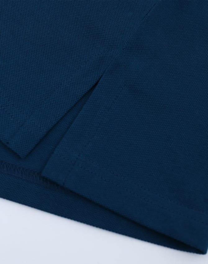 A close-up of a navy ultrafine cotton pique polo, featuring textured fabric and clean hems.