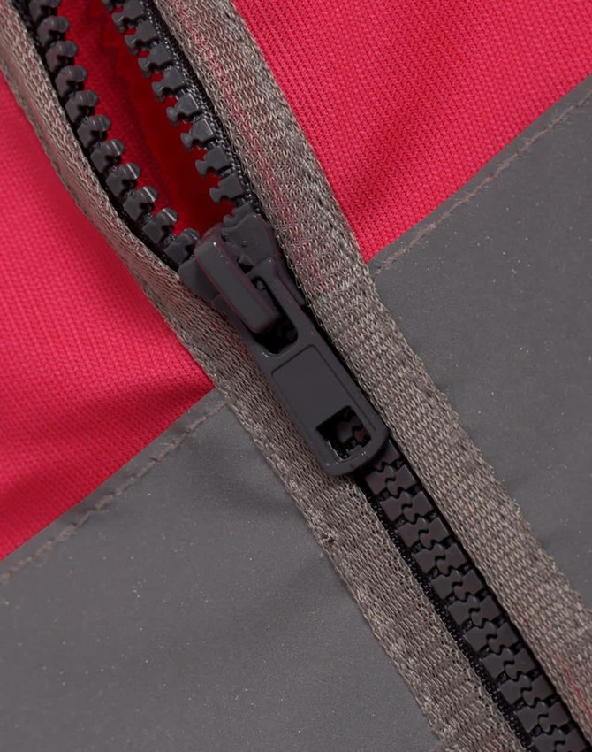 A close-up of a zippered section of a hi-vis vest, featuring a red and grey colour scheme with a utility pocket.