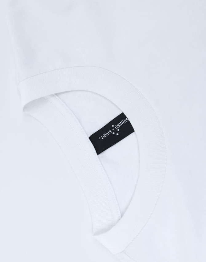 A white unisex heavy cotton oversized tee featuring a rounded neckline and a tag on the inside.