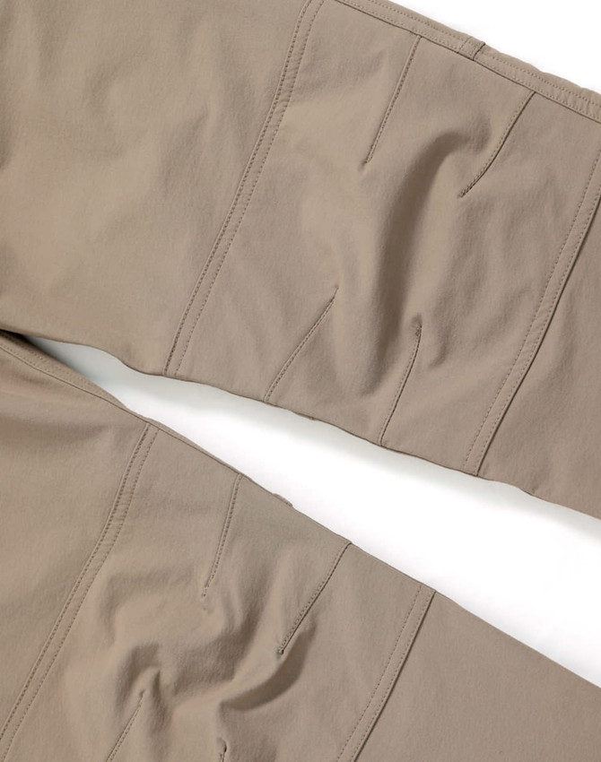 Flexible work pants in a tan colour, featuring detailed stitching and a subtle logo on the fabric.