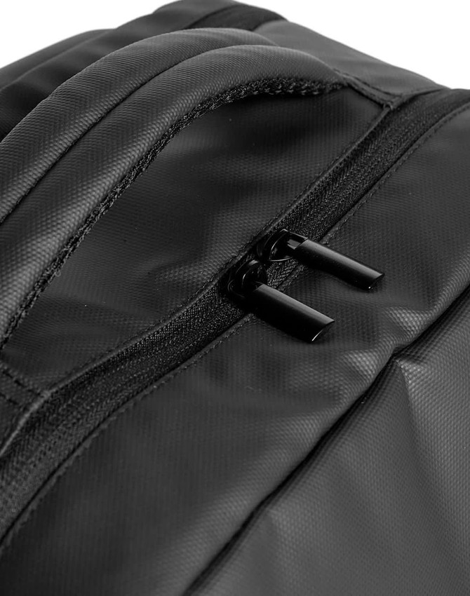 A close-up view of a black PU backpack featuring a zippered pocket and a sleek design. The backpack has a logo.