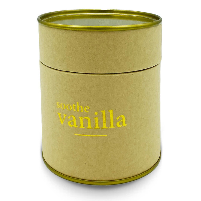 A large, cylindrical candle in a kraft paper container with a gold lid, labelled "soothe vanilla".