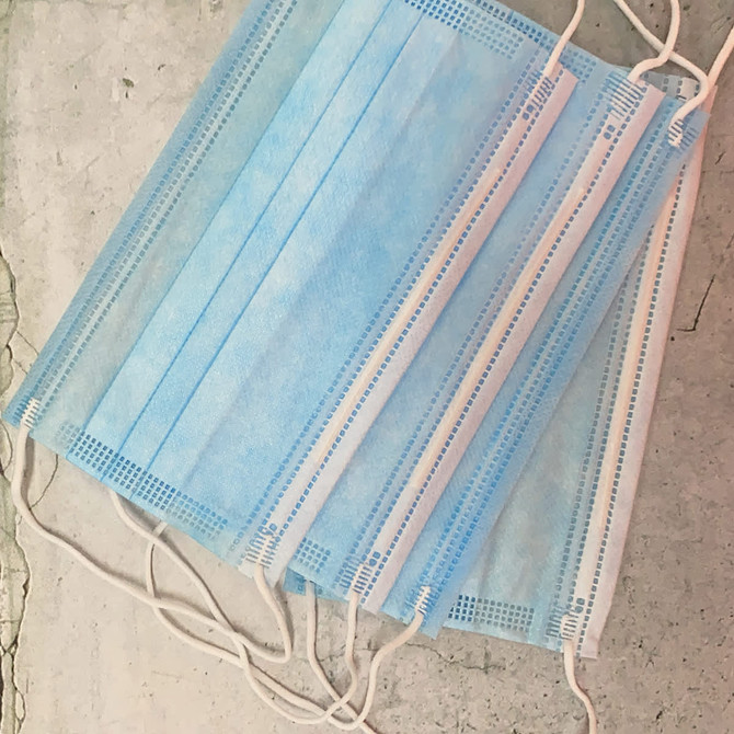 A set of three blue triple-layered cloth face masks with elastic ear straps, featuring a simple design.