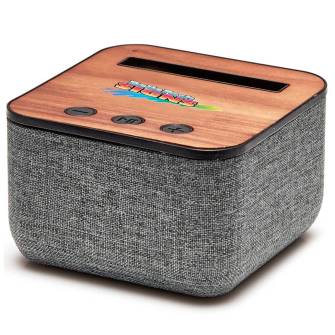 A square Bluetooth speaker with a wooden top and grey fabric covering, featuring control buttons and a logo.