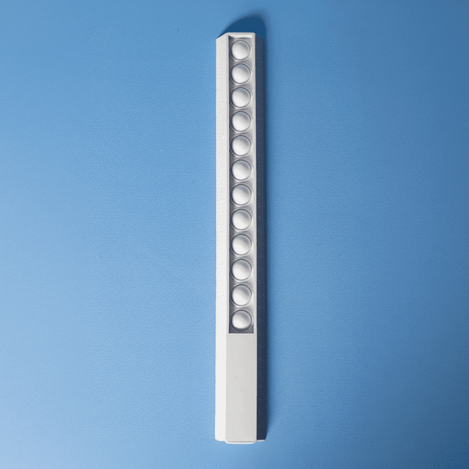 A white 30cm popper ruler featuring multiple poppers along its length, set against a blue background.