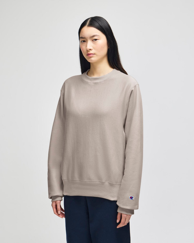 A grey Champion Reverse Weave® adult crew sweatshirt is displayed on a model in a neutral setting.
