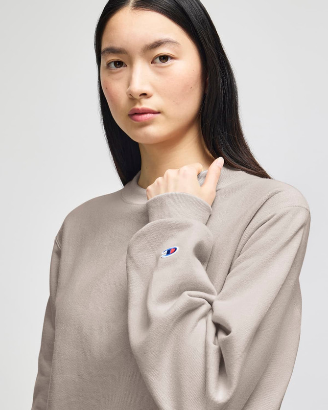 A model wearing a grey Champion Reverse Weave® adult crew sweatshirt, showcasing a casual style.