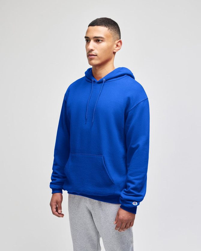 A blue pullover hooded sweatshirt with a front pocket and a logo. The model wears grey sweatpants.