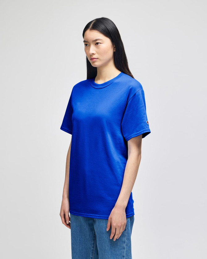 A blue Champion adult short-sleeve T-shirt displayed on a model, featuring a logo on the sleeve.