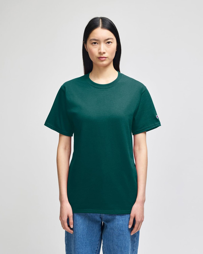 A green Champion Adult Short-Sleeve T-Shirt displayed on a model, featuring a logo on the sleeve.