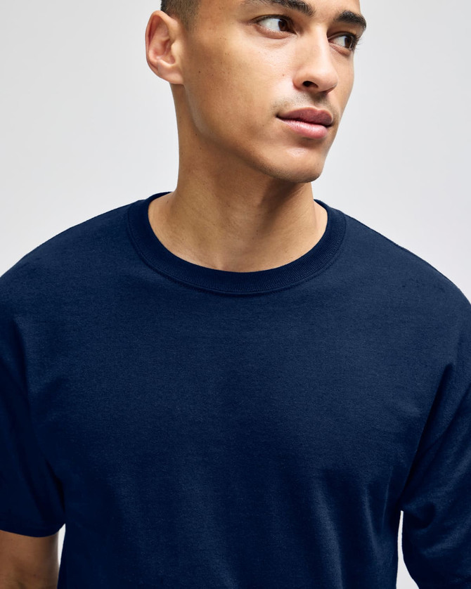 A navy short-sleeve t-shirt on a young man, featuring a simple design and a logo on the garment.