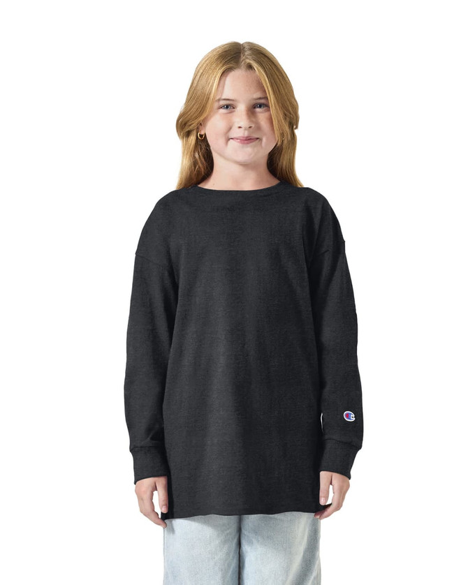 A youth long sleeve T-shirt in black, featuring a logo, worn by a girl with long hair.