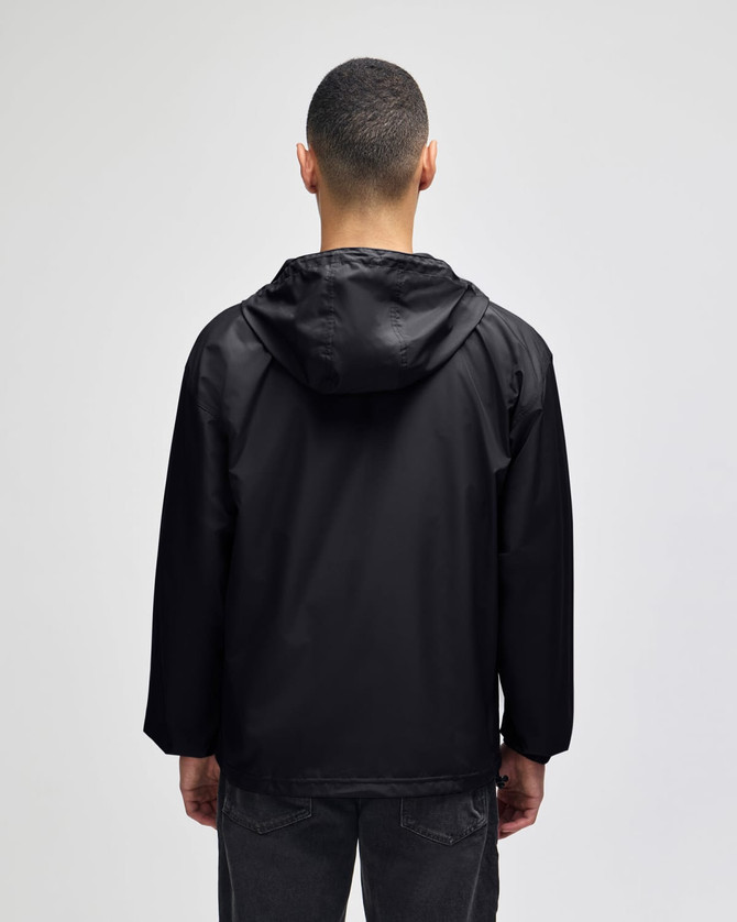 A black packable anorak jacket with a hood, viewed from the back, featuring a logo on the neck area.