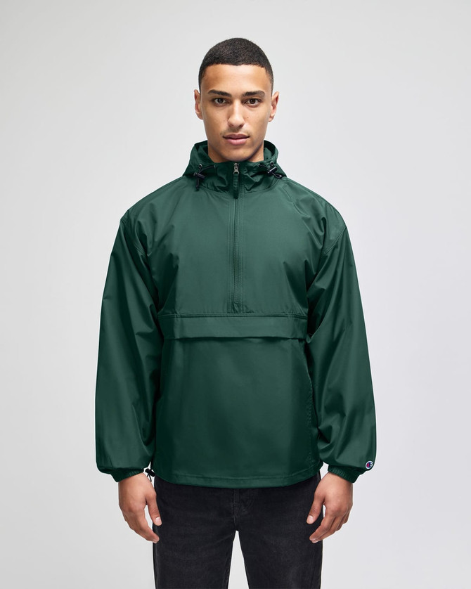 A green packable anorak jacket with a hood, featuring a front pocket and logo branding.