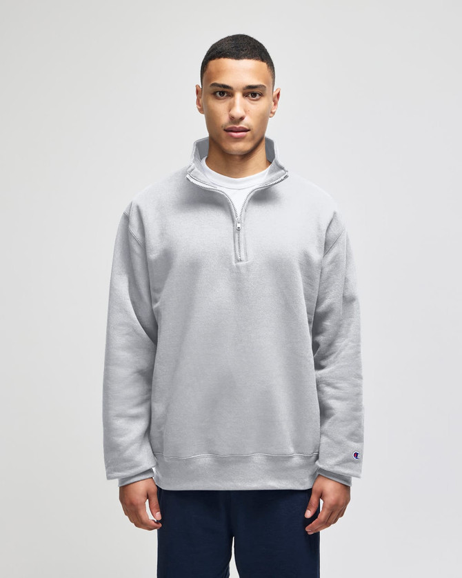 A grey Champion Powerblend® adult quarter-zip pullover, featuring a front zip and a logo. Casual and comfortable design.