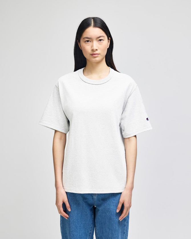 A grey Champion Adult Heritage Jersey T-Shirt displayed on a male model against a plain background.