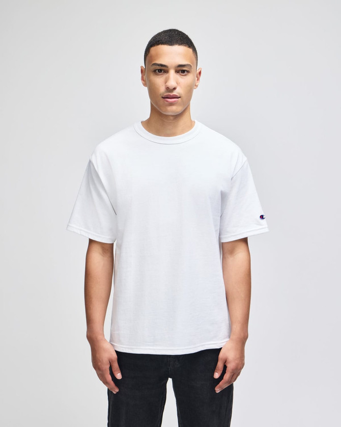 A white Champion Adult Heritage Jersey T-Shirt displayed on a model against a plain background.