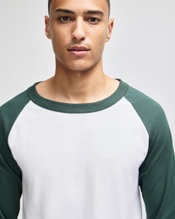 A raglan baseball t-shirt featuring a white body and green sleeves, designed for adults. Includes a logo.