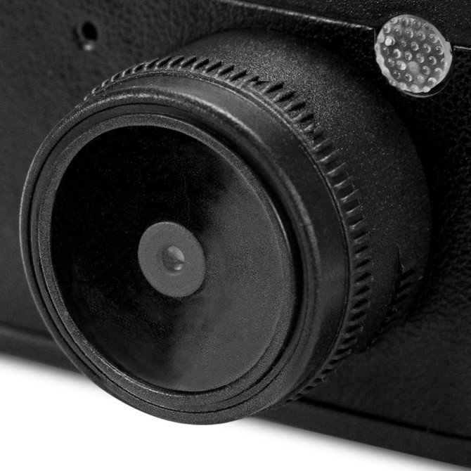 A black mini camera featuring a circular lens and textured body, with a small light detail.